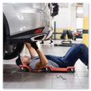 Mechanic checking tires and brakes on a touring car