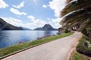 Cabriolet cruising along a Swiss lake road with mountains